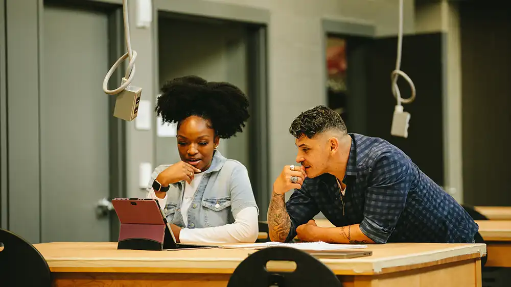 Female and male students working together in a lab.