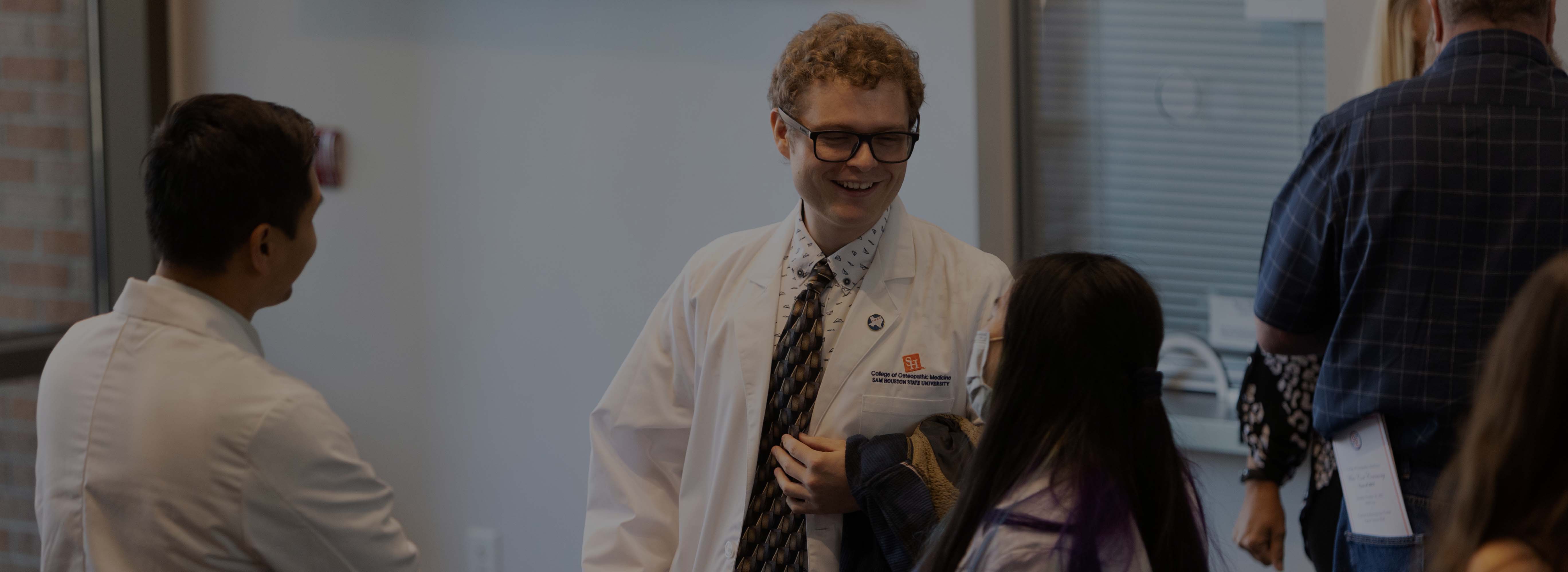 person smiling in white coat