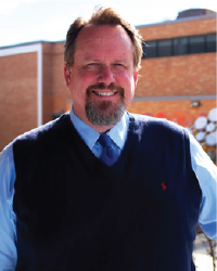 Dr. Gene Roberts smiles for a photo.