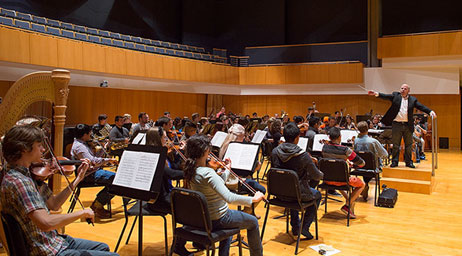 A group of students are playing in an orchestra.